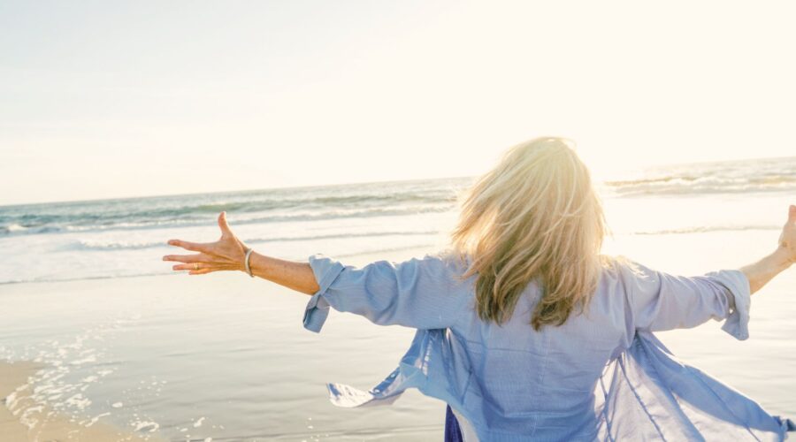 Woman with arms outstretched, symbolizing openness and balance in emotional wellness. Explore 8 effective strategies to improve your emotional health and wellbeing at Embodied Wellness Center.