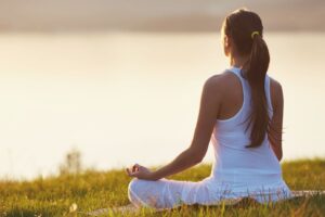 Female practicing mindfulness meditation for stress relief and focus enhancement